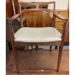A mid 20th century Danish elbow dining chair with a pierced back and pad seat on tapering legs