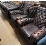 A brown leather chesterfield four piece suite
