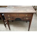 A George III oak lowboy with a planked top above three drawers and an arch on square tapering legs