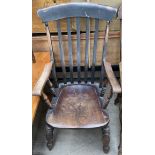 A 19th century slat back kitchen elbow chair with a solid seat on turned legs