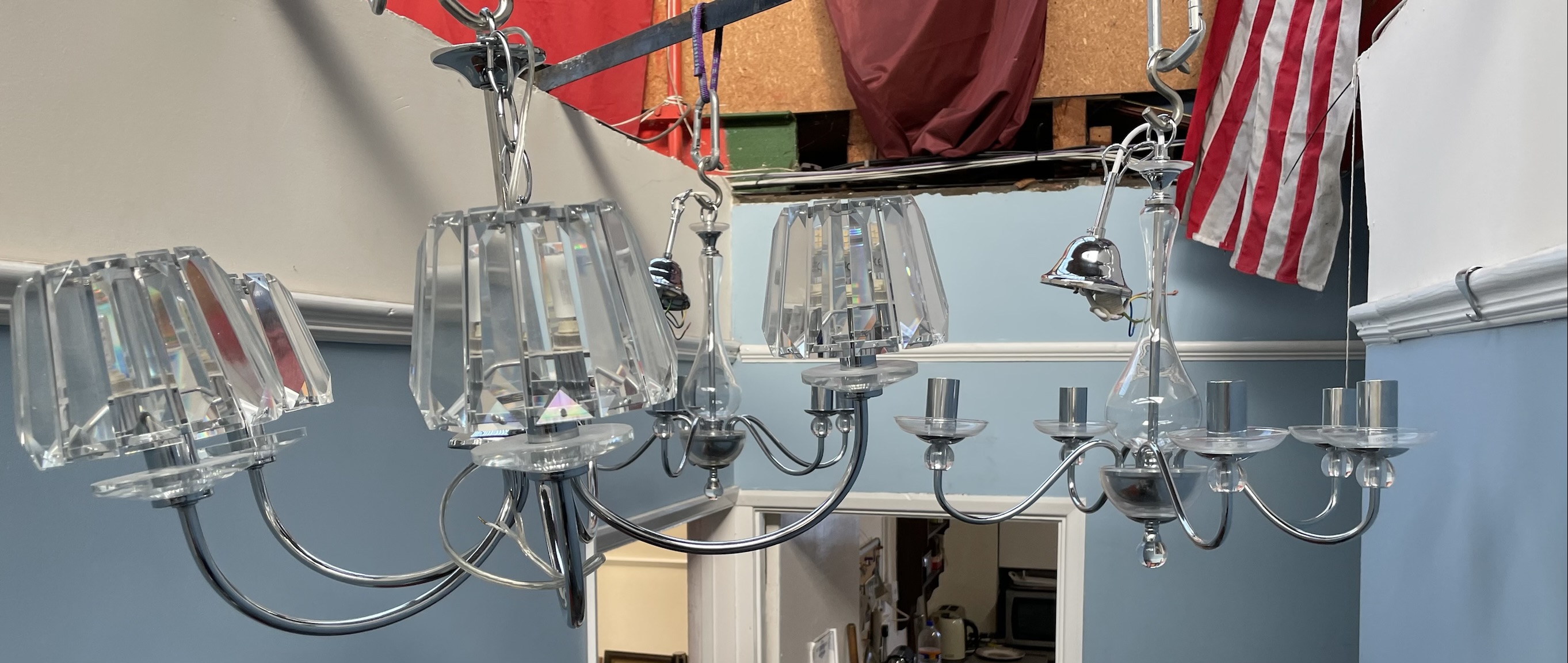 A pair of chrome and glass five branch chandeliers together with another chandelier