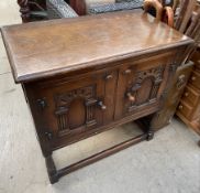 A 20th century oak side cabinet with a rectangular top above a pair of arched cupboard doors on