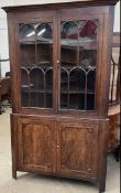 A George III oak standing corner cupboard with a moulded cornice above a pair of glazed doors the
