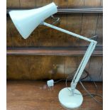 A cream anglepoise lamp on a weighted base