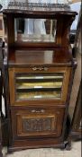An Edwardian walnut music cabinet, with a three quarter gallery, mirrored back,