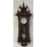 A late Victorian Vienna regulator type wall clock, with a carved cresting,