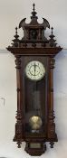 A late Victorian Vienna regulator type wall clock, with a carved cresting,