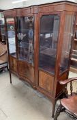 An Edwardian mahogany display cabinet with a serpentine front, with a glazed door,