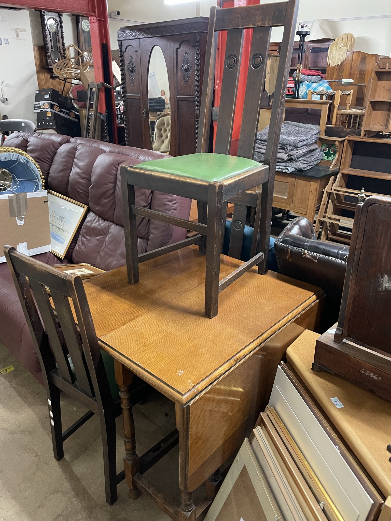 An oak drop leaf dining table together with three chairs