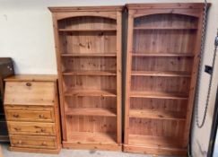 A pair of pine bookcases with moulded cornices together with a small pine bureau.