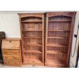 A pair of pine bookcases with moulded cornices together with a small pine bureau.