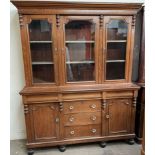 A late Victorian oak dresser with a moulded cornice above three glazed doors,