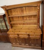 A 20th century pine kitchen dresser, the moulded cornice above two shelves,