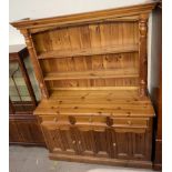 A 20th century pine kitchen dresser, the moulded cornice above two shelves,