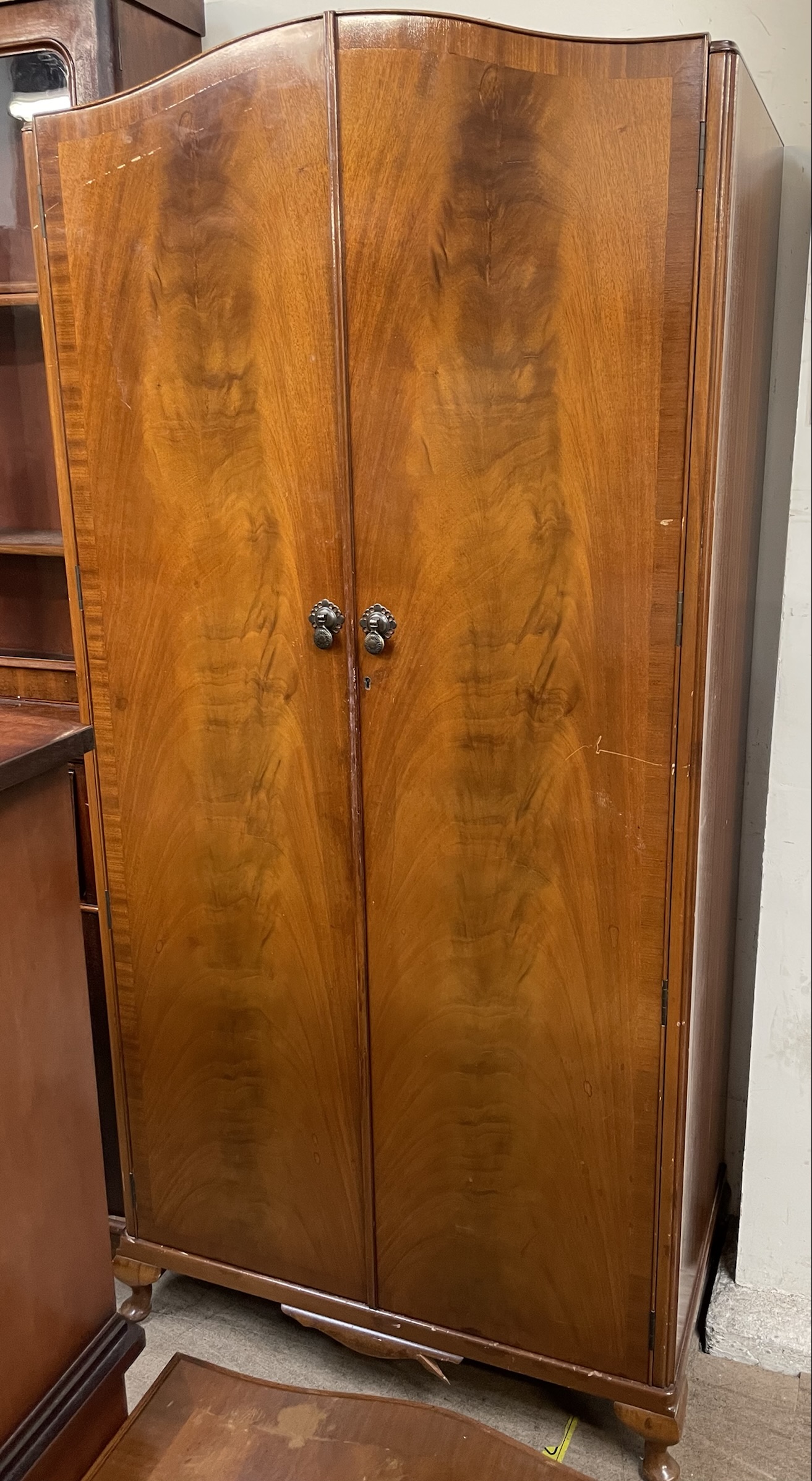 A 20th century walnut wardrobe together with a 20th century mahogany side cabinet and a serpentine