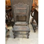 An 18th century oak chair with a carved pad and planked seat