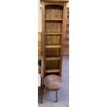 A pine bookcase together with a wicker topped stool