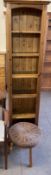 A pine bookcase together with a wicker topped stool