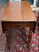 A Victorian oak Pembroke table with drop flaps and a frieze drawer on turned legs