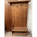 A pine hall stand, with a moulded cornice and a planked back with shoe rack to the base, 110.