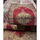 A pair of red ground rug with a central medallion together with a smaller similar example and two