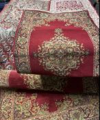 A pair of red ground rug with a central medallion together with a smaller similar example and two