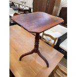 A 19th century mahogany tripod table with a rectangular top with cut corners on a baluster column