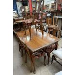 A 20th century walnut dining suite comprising an extending dining table,
