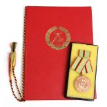 MDI Verdienstmedaille in Bronze mit Urkundemit Interimsspange dazu Urkunde von 1987 in
