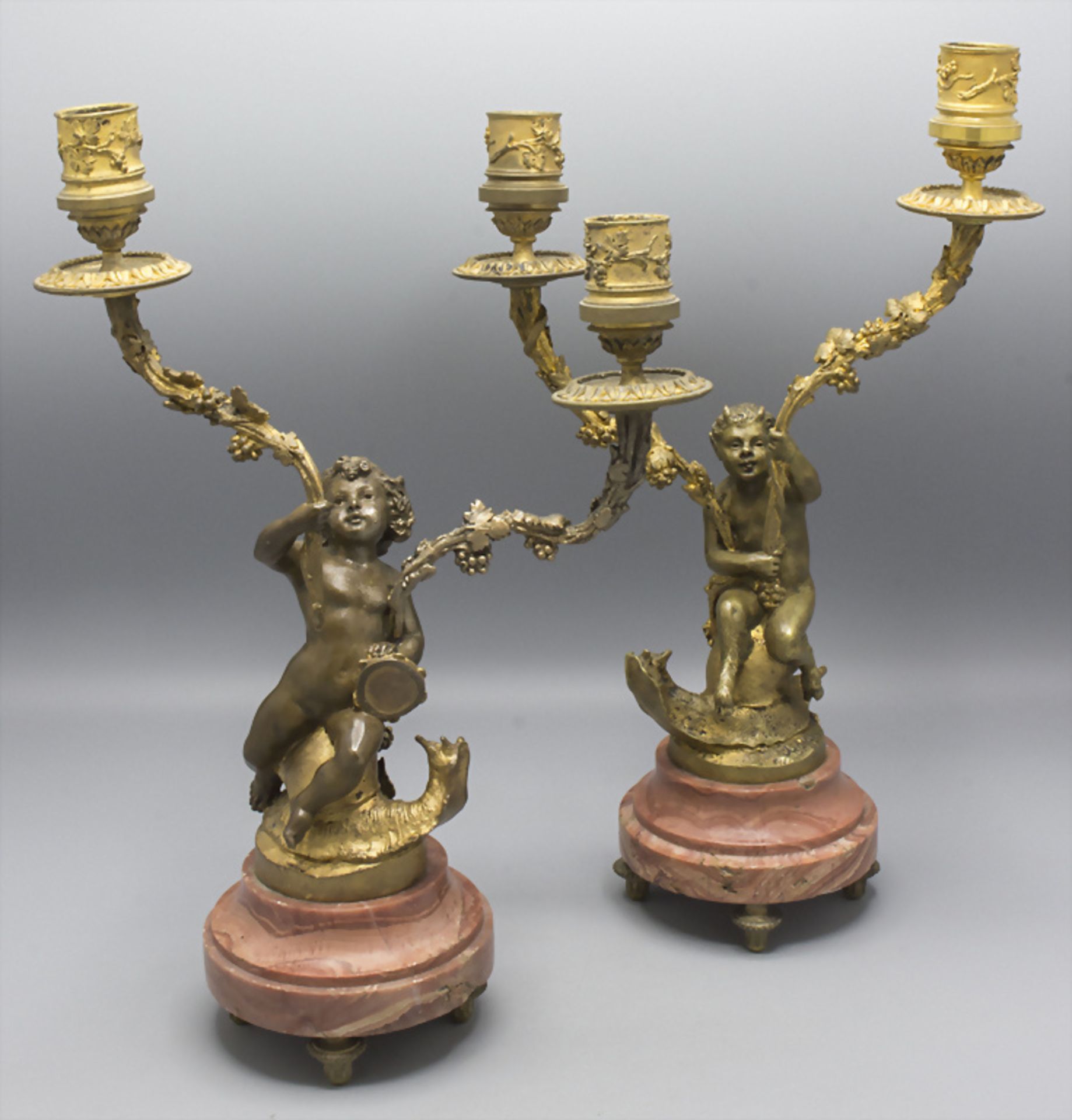 Paar figürliche Bronzeleuchter / A pair of figural candleholders with a girl and a faun on ...