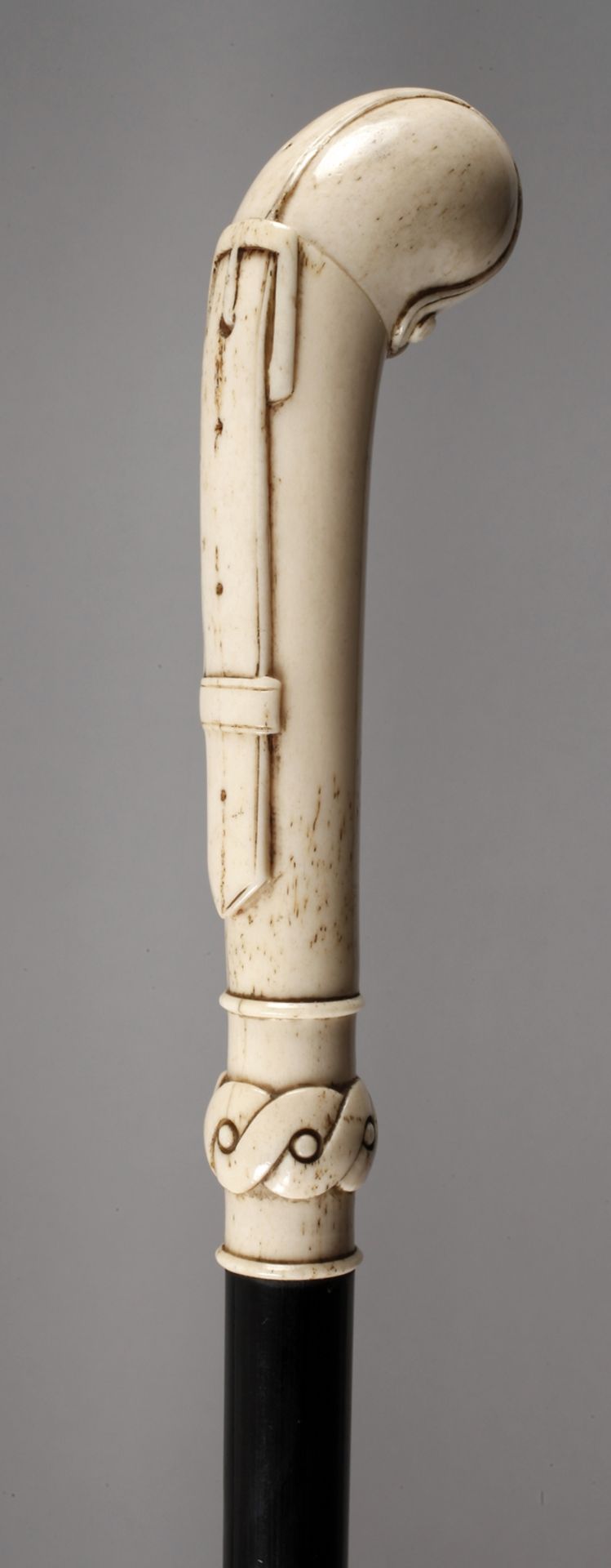 Spazierstock Bein um 1910, schlankes Griffstück mit reliefiertem Gürtelmotiv, Manschette in