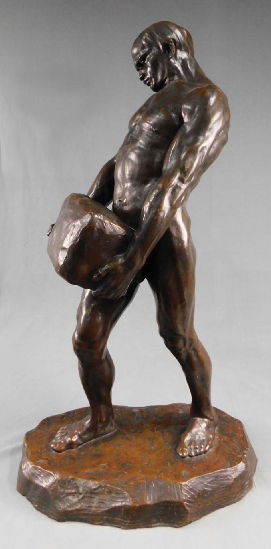 UNDEUTLICH SIGNIERT (XIX - XX). Bronzefigur, Mann mit Stein.