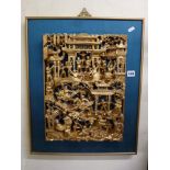 A framed carved Thai giltwood wall panel depicting every day life scenes [next to s77] TO BID ON