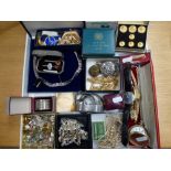 A tray of costume jewellery, including beads and earrings, a silver napkin ring, sets of gilt-