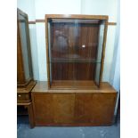 An English Art Deco burr walnut vitrine, the glazed upper part on a wide base enclosed by a pair