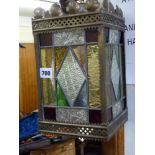 A late Victorian square hall lantern in pierced brass and leaded, coloured, and patterned glass TO