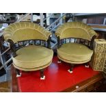 A pair of Victorian love-seats with ebonized and gilt frames comprising two revolving chairs of