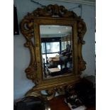 A very large wall mirror of dramatic form, the rectangular plate in a gilt frame moulded with the