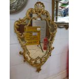 An ornate wall mirror of triangular shape in a rococo, gilt painted aluminium frame. TO BID ON