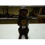 A novelty carved wood mantel timepiece, early 20th century, in the form of a seated chimpanzee, with