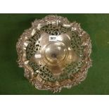 An Edwardian silver ornate pierced fruit bowl, on scroll feet, 10.8 in across, Sheffield 1906, 22