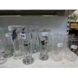 A shelf of glass ware including 1950s lemonade glasses decorated with swans plus others, a pair of