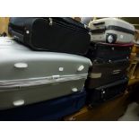 A large collection of luggage including five suitcases, two carryon bags and a quantity of further