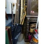 A quantity of long farming implements and walking sticks. [next to garage door] TO BID ON THIS LOT