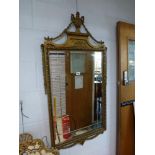 A classical English style wall mirror the rectangular plate beneath a moulded cornice with urn and