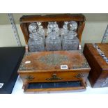 A late Victorian brass-mounted oak tantalus with spring-loaded games drawer, retaining three