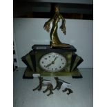An Art Deco mantel timepiece in green onyx and slate, surmounted by a cold-painted metal figure of