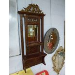 A charming Indonesian lacquered hanging mirror, with small rectangular plate and two shelves beneath