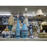 Two shelves of mixed china and glass including two large Oriental table lamps, a large white table