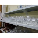 A shelf of glassware including cut glass whisky tumblers, brandy balloons, wine glasses, sherry